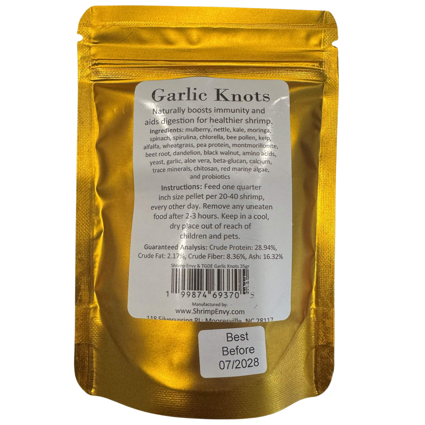 A 35g Shrimp Envy stand-up pouch of 'Garlic Knots' shrimp pellets, showing the back of the packaging with product details, ingredients, and instructions on a white background.